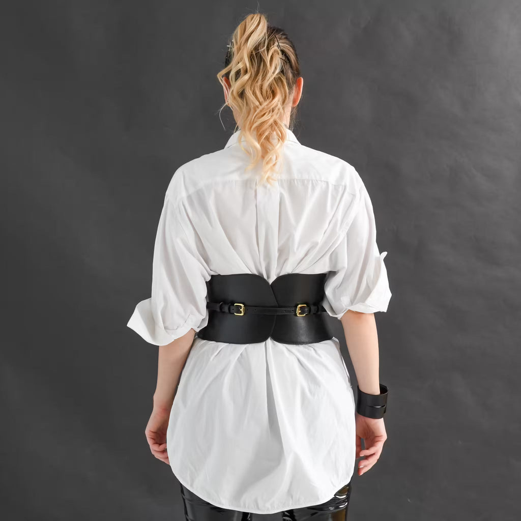Aria Margo wide black Italian leather corset belt worn over a white shirt, featuring two adjustable gold buckles.