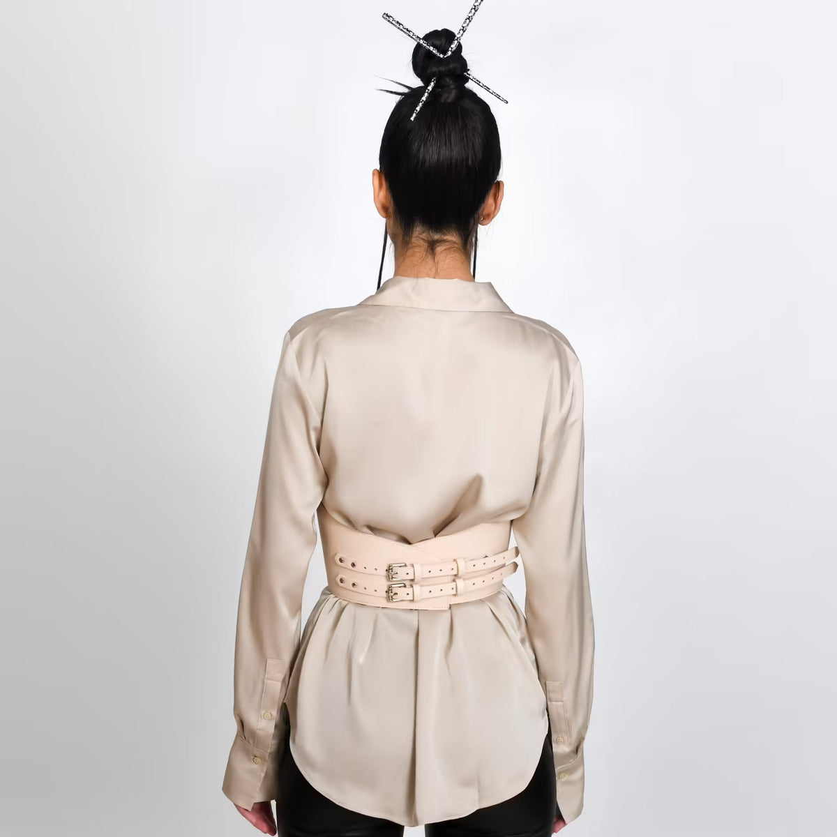 Aria Margo beige leather under-bust belt with dual buckles worn over a silk shirt, back view.