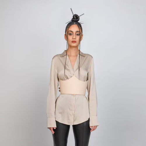 Aria Margo beige leather under-bust belt worn over a silk shirt, featuring adjustable buckles and sculpted fit.