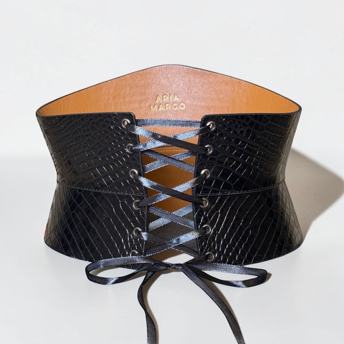 Aria Margo black croc-embossed leather corset belt with satin lacing and an hourglass silhouette.
