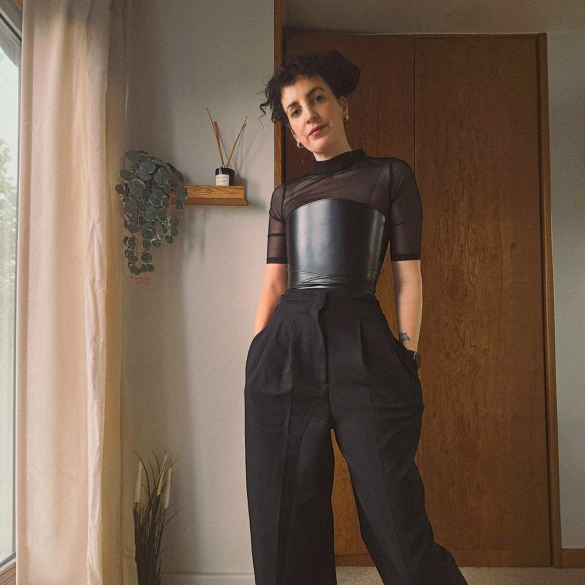 Aria Margo black leather cord top belt worn over a sheer black top and trousers for a structured waist silhouette