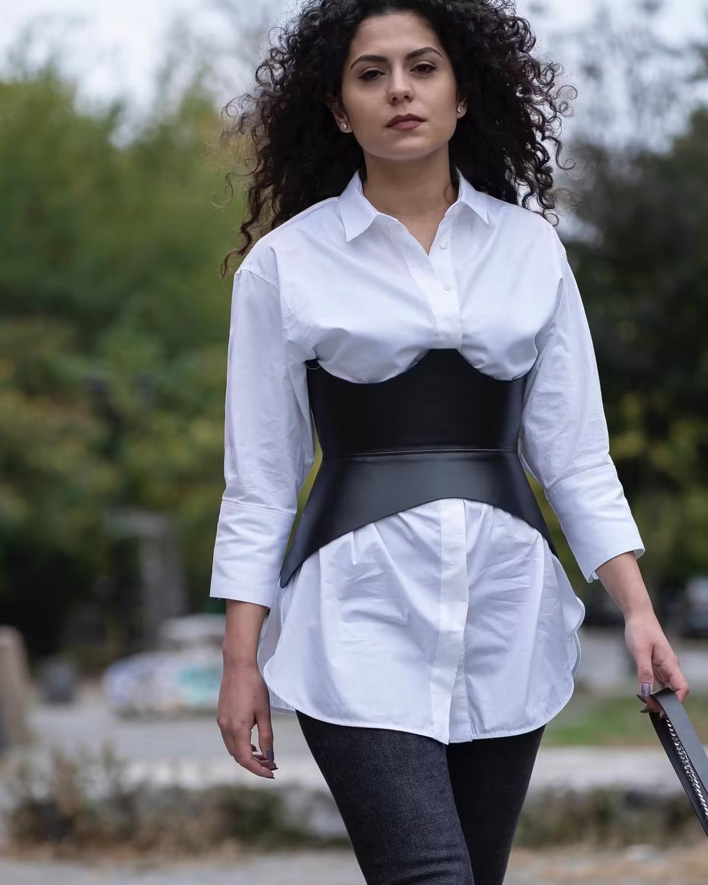 Aria Margo black Italian leather corset belt worn over a white button-down shirt for a sculpted silhouette.