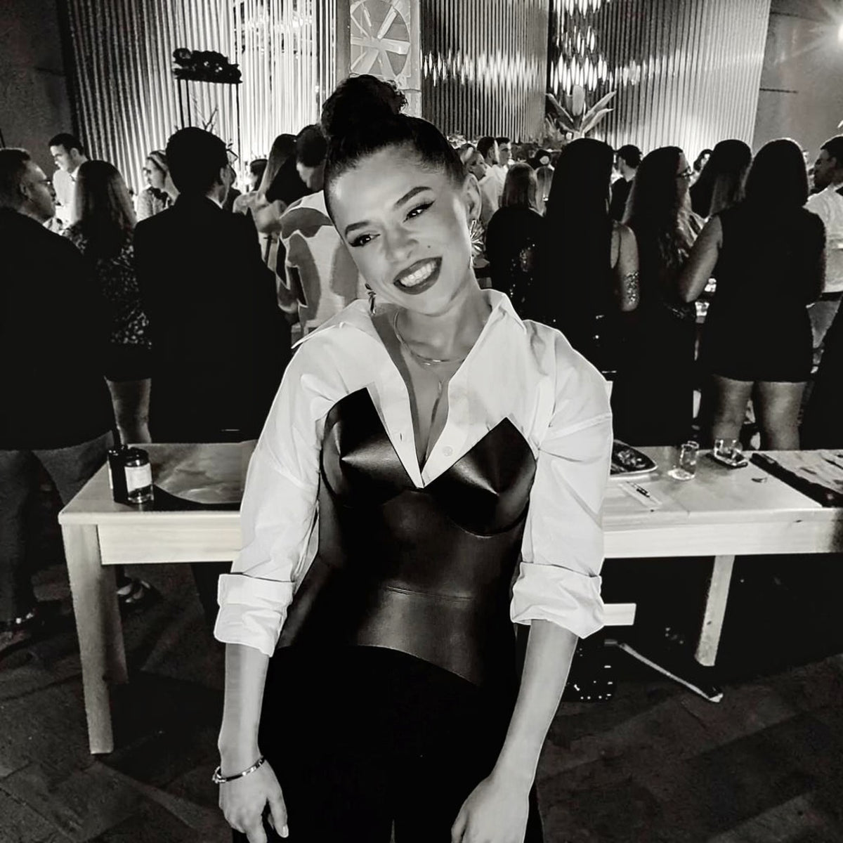 Aria Margo black leather full body corset belt worn over a white button-down shirt at an evening event