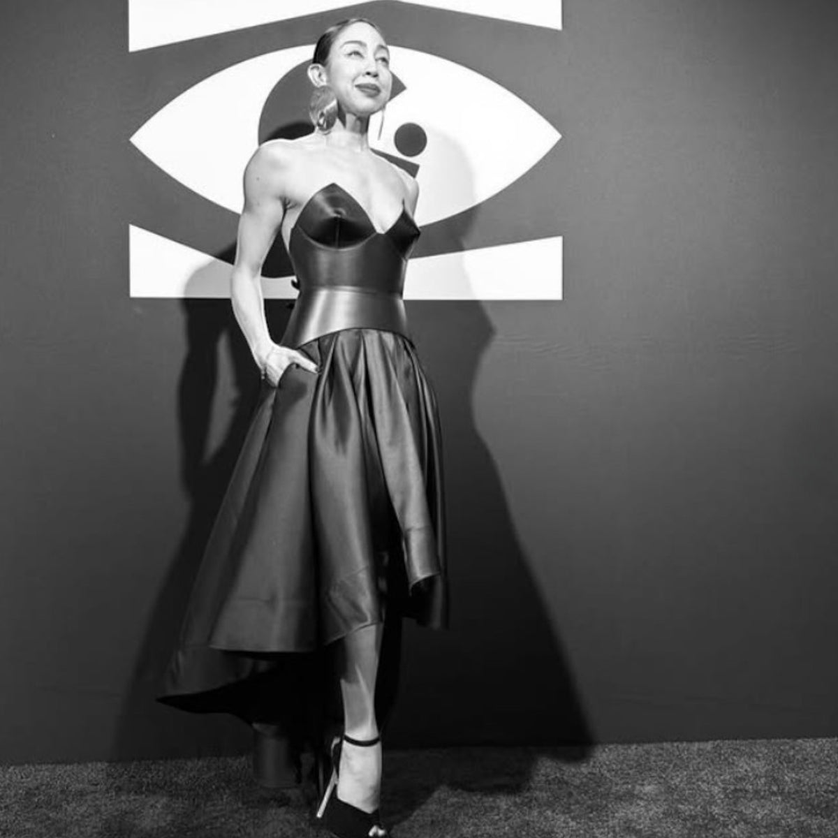 Aria Margo  black leather full body corset belt worn over a structured dress for a bold, futuristic silhouette.