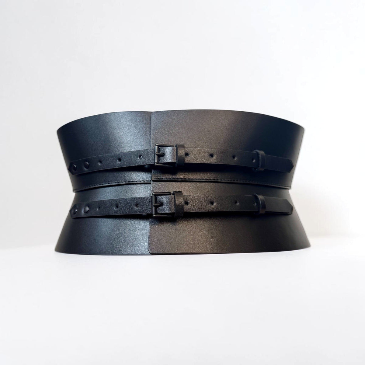 Aria Margo black leather corset belt with an hourglass silhouette and two adjustable buckle straps.