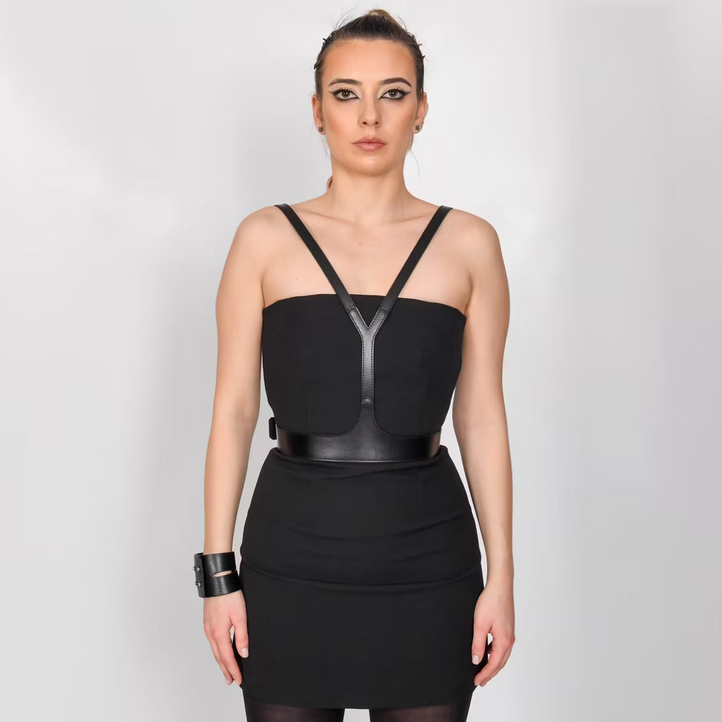 Aria Margo black leather V-neck harness belt worn over a black strapless dress to frame the upper body.