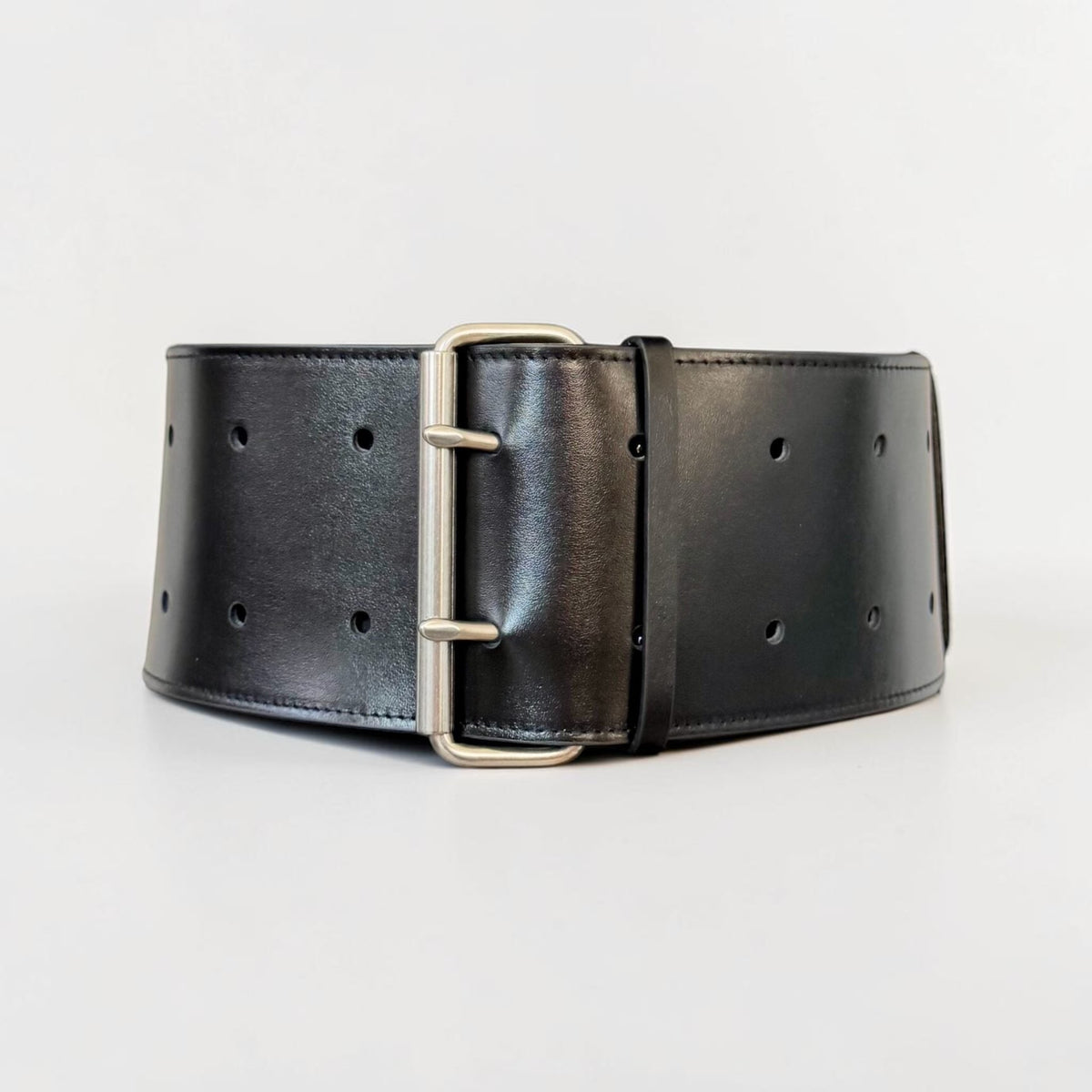 Aria Margo black leather military coat belt with a silver-tone double-prong buckle on a mannequin torso.