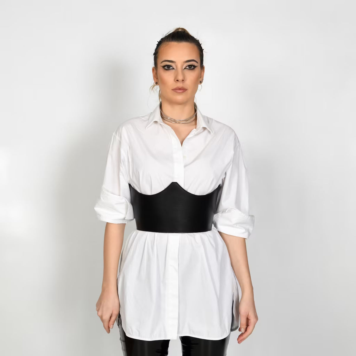 Aria Margo black Italian leather under-bust belt worn over a white button-down shirt for a structured silhouette.