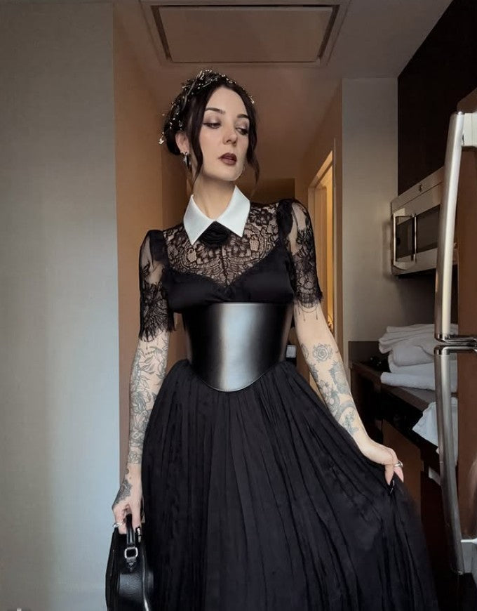 Aria Margo black leather under-bust belt worn over a black lace dress with a white collar