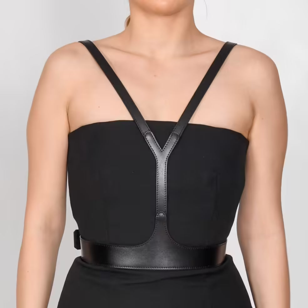 Aria Margo black leather V-neck harness belt worn over a black strapless dress to frame the upper body.