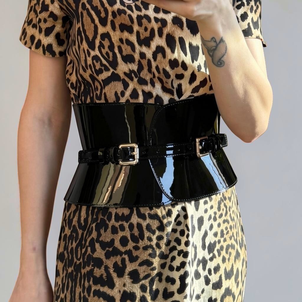 Aria Margo wide black patent leather corset belt with double buckles worn over a leopard print dress