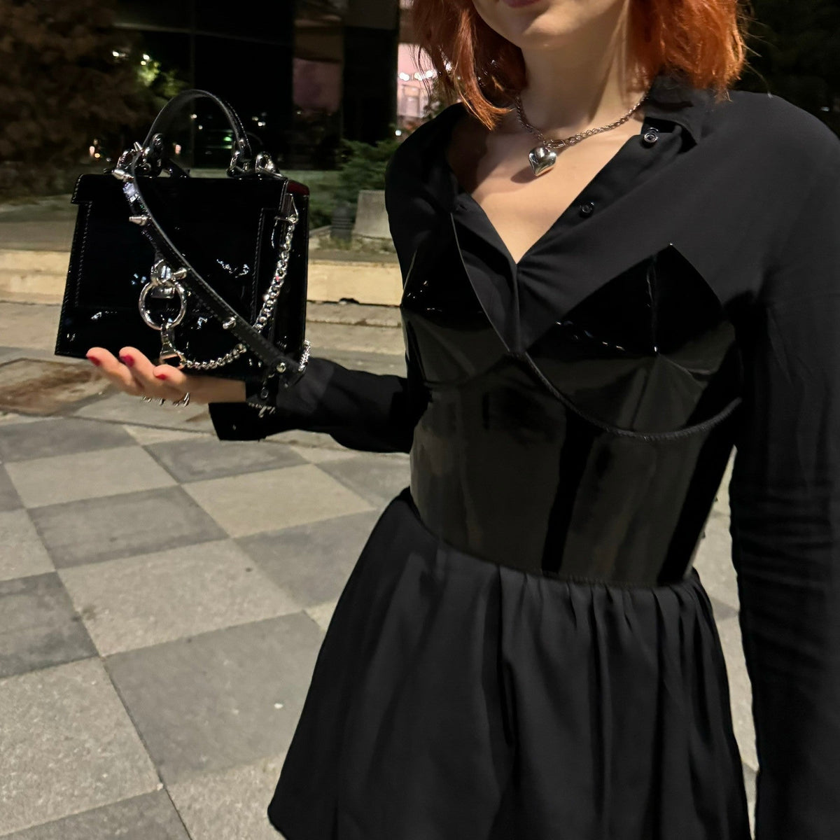 Aria Margo black patent leather over-bust corset worn over a black shirt, featuring a high-shine finish.