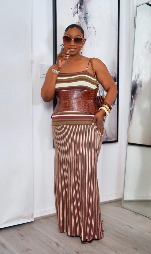 Aria Margo brown croc-embossed leather corset belt worn over a striped maxi dress by a woman in sunglasses.