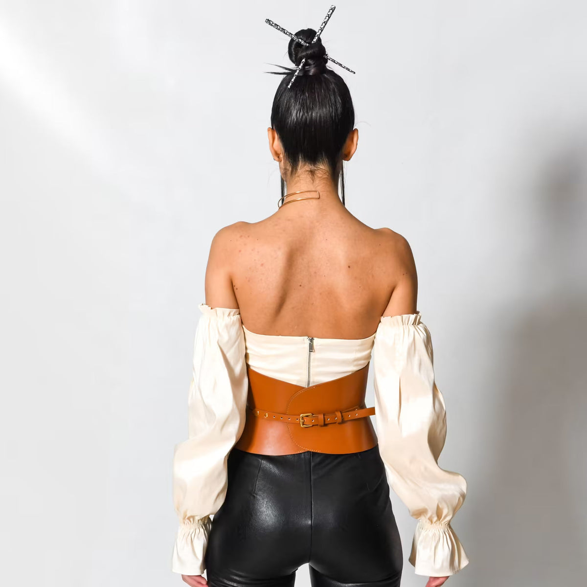Aria Margo brown Italian leather hourglass corset belt worn over a cream off-shoulder top and black trousers