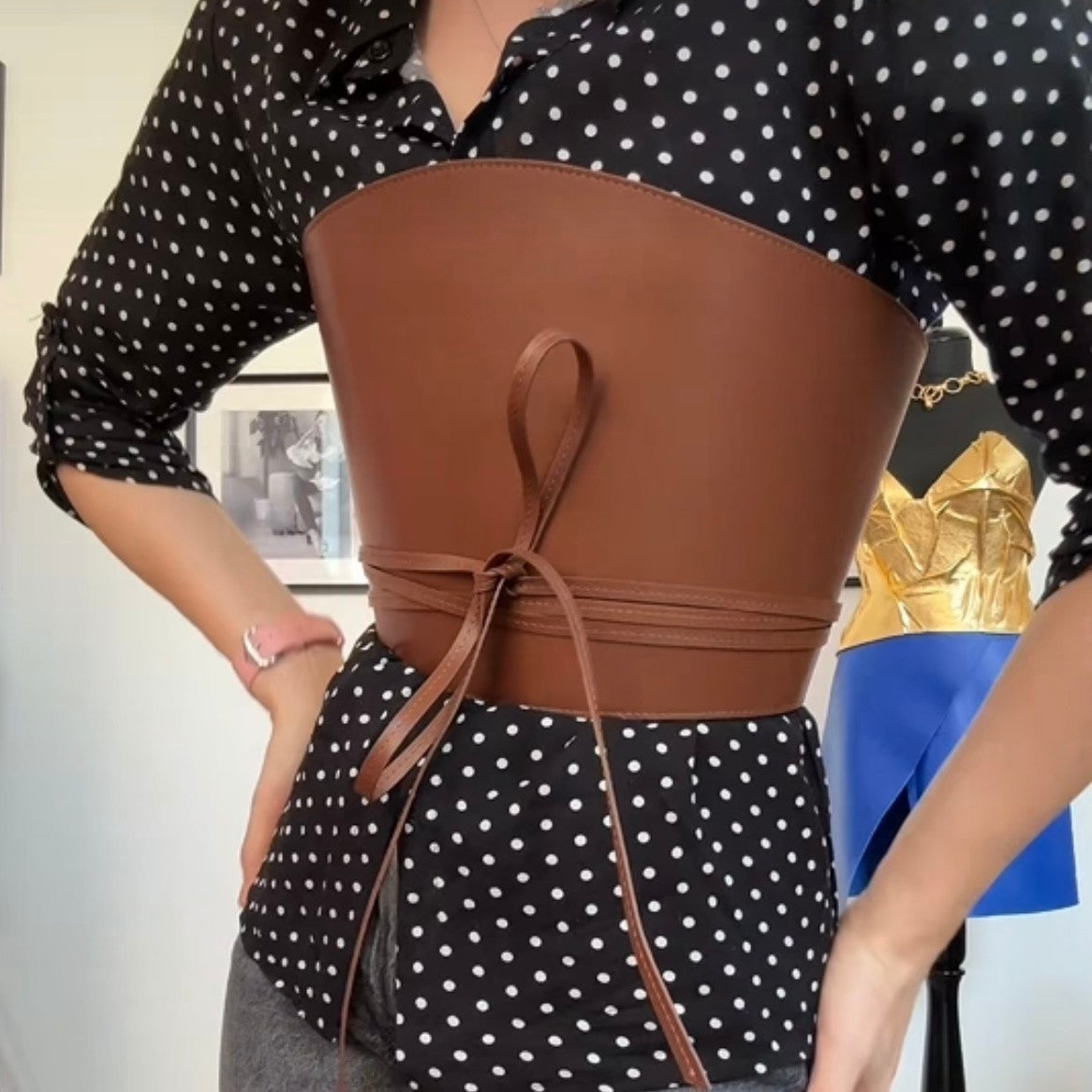 Aria Margo brown leather corset belt with wrap-around cord lacing worn over a black and white polka dot shirt.