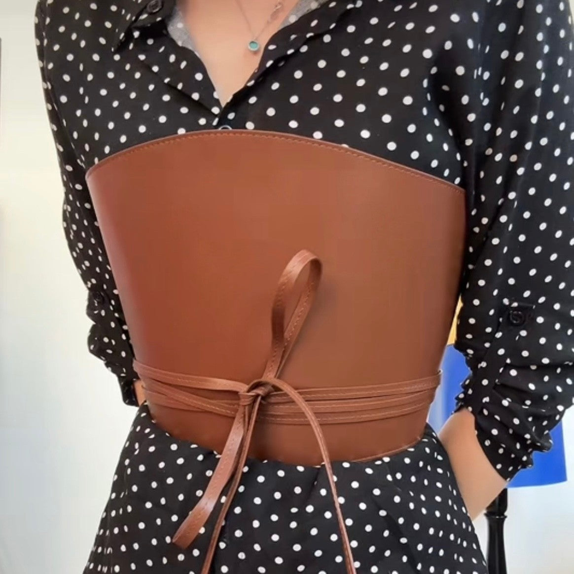 Aria Margo brown leather corset belt with wrap-around cord ties worn over a black and white polka dot shirt