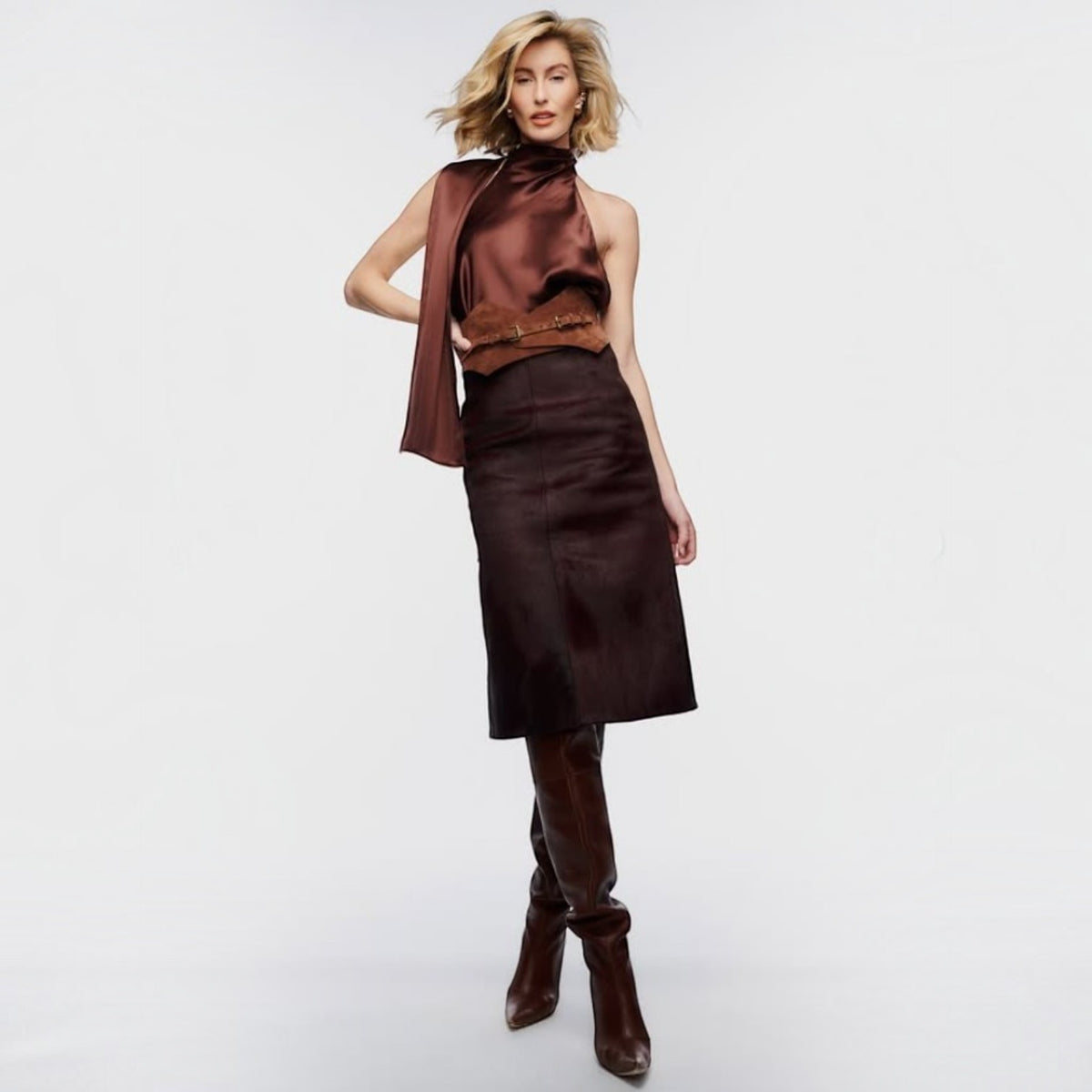 Aria Margo brown suede Thorns corset belt worn over a dark brown midi skirt and satin halter top
