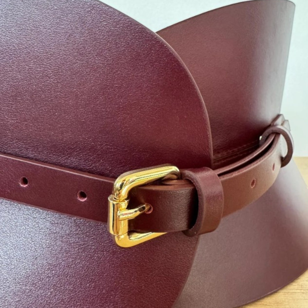 Aria Margo burgundy Italian leather hourglass corset belt with a gold-toned buckle and structured design.