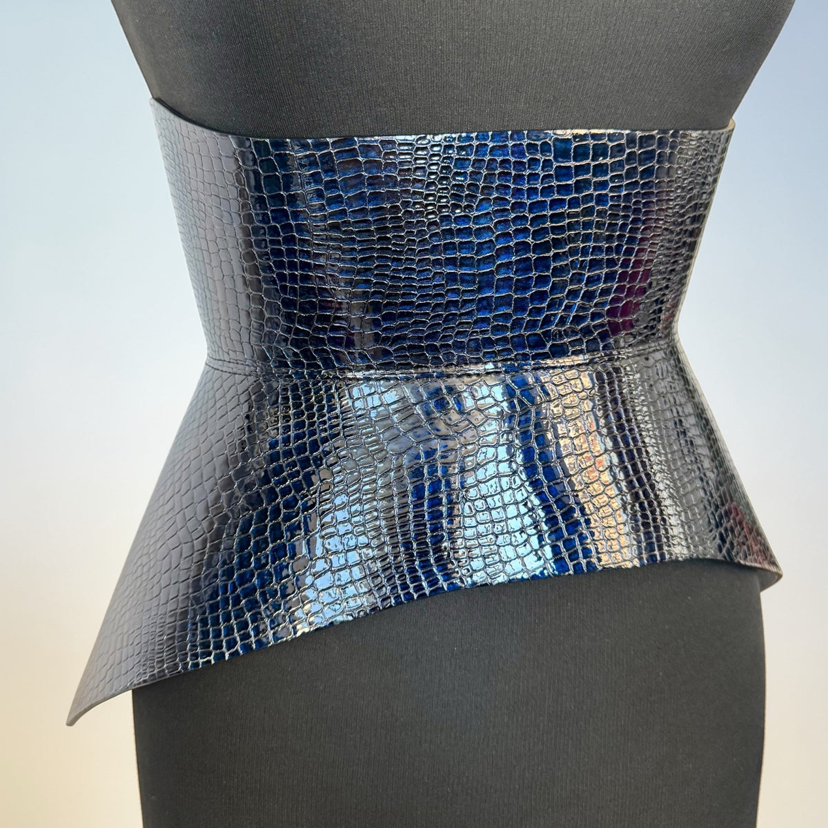 Aria Margo Hallo corset belt in dark blue croc-embossed Italian leather on a black mannequin torso.