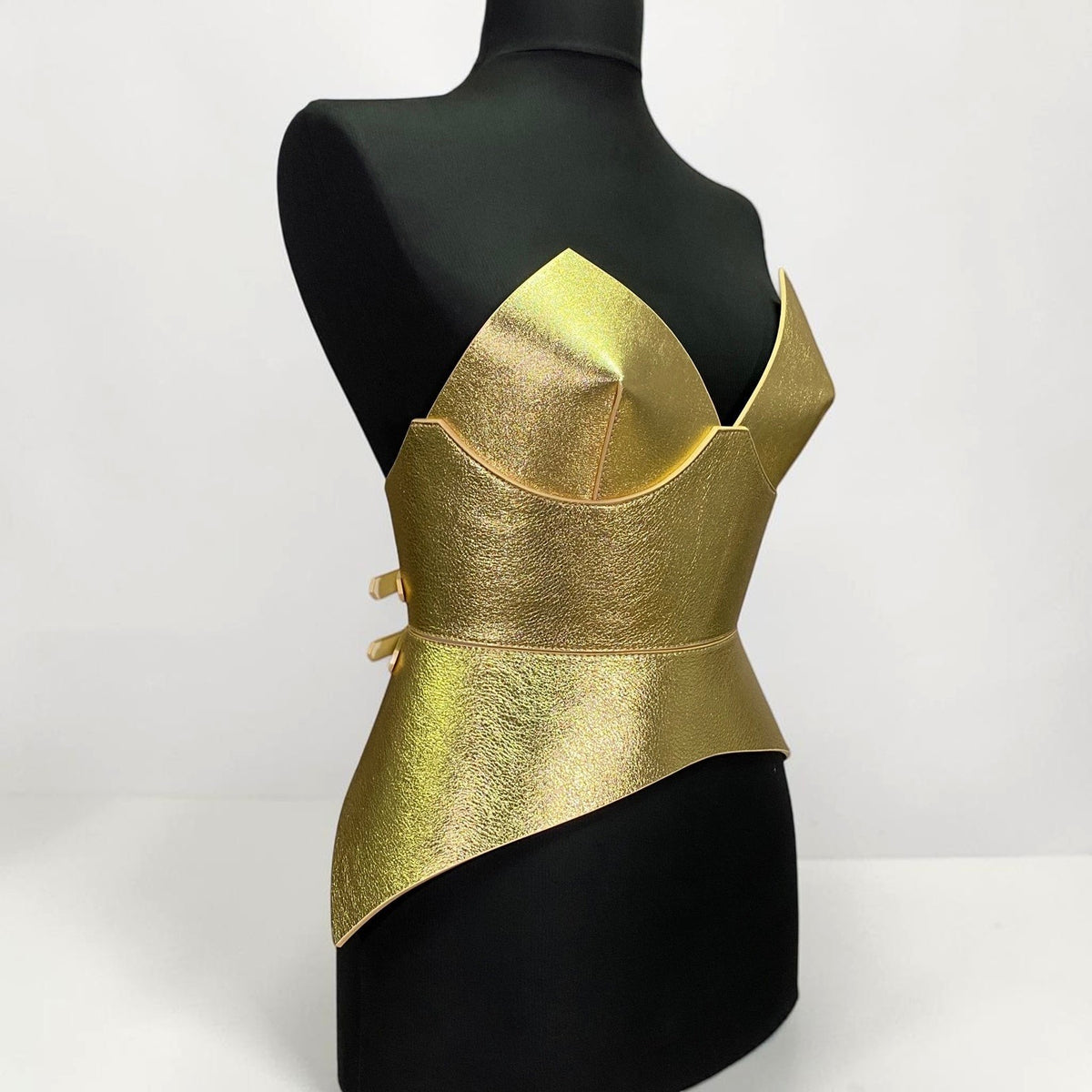 Aria Margo gold metallic leather corset belt with a structured, futuristic silhouette on a black mannequin.