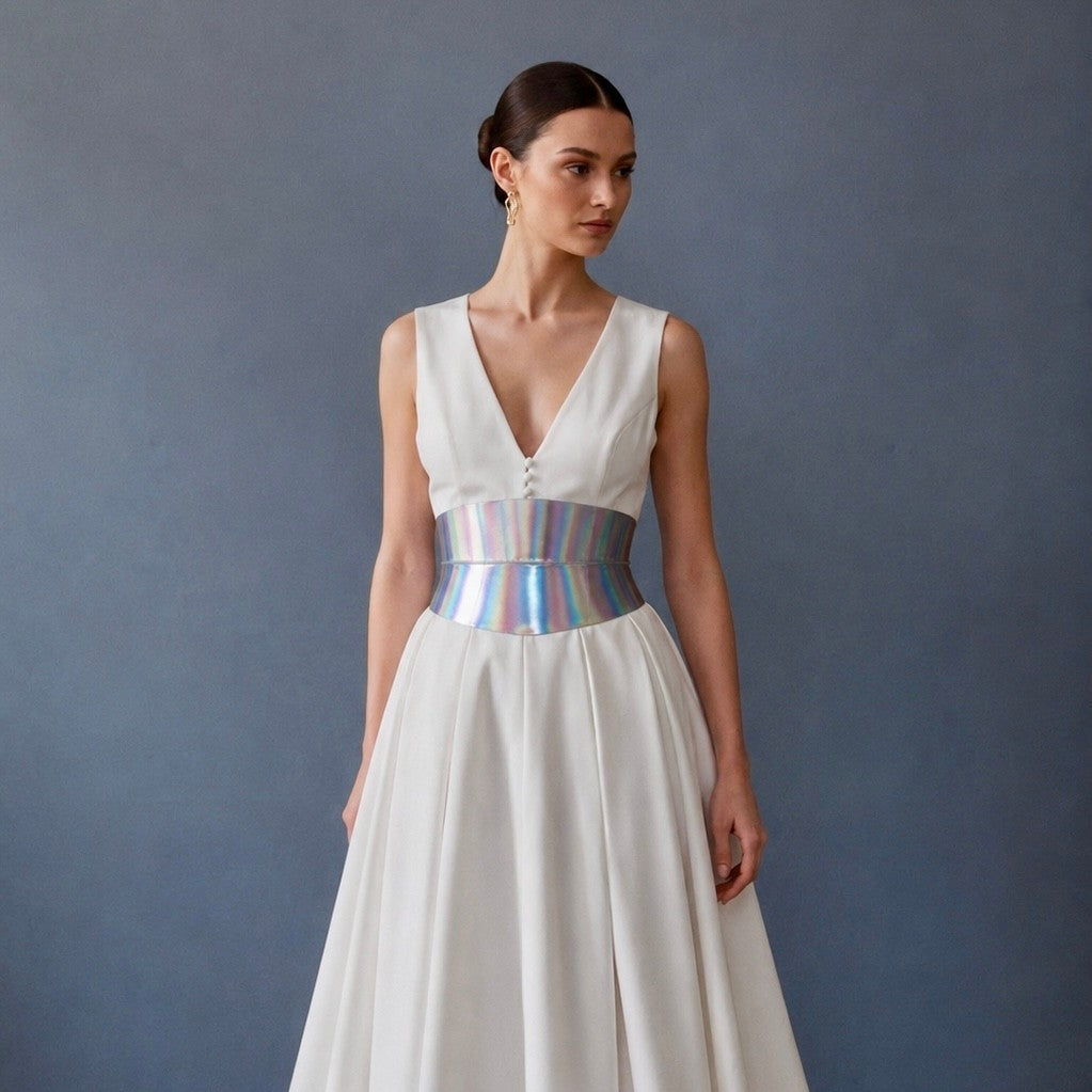 Aria Margo Eclipse Mini holographic silver leather corset belt worn over a white dress by a model