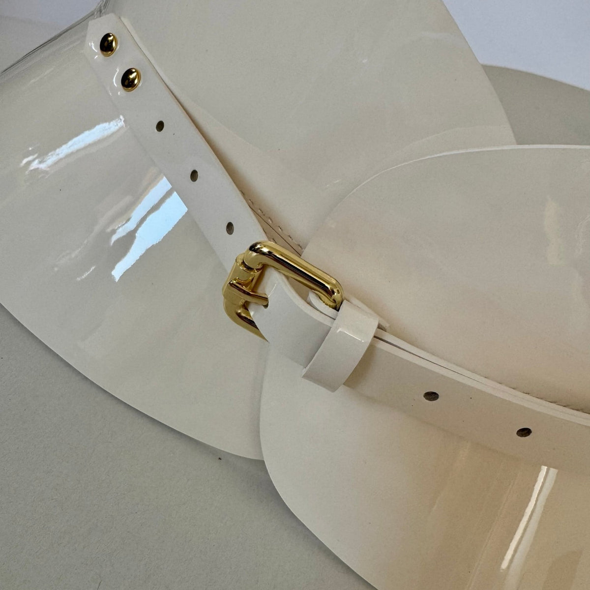 Aria Margo ivory patent leather hourglass corset belt with a gold buckle and high-shine finish.
