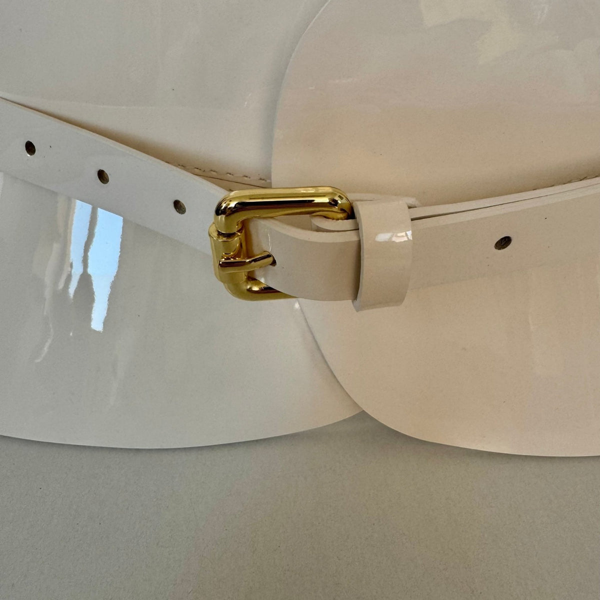 Aria Margo ivory patent leather hourglass corset belt featuring a high-shine finish and a gold-toned buckle.
