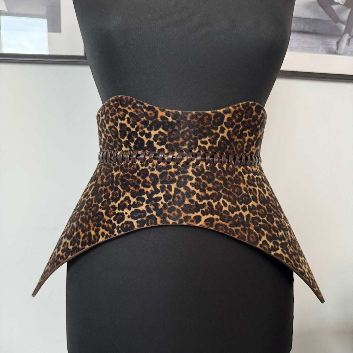 Aria Margo Nova leather corset belt in leopard print pony hair with hand-worked lacing on a mannequin torso.