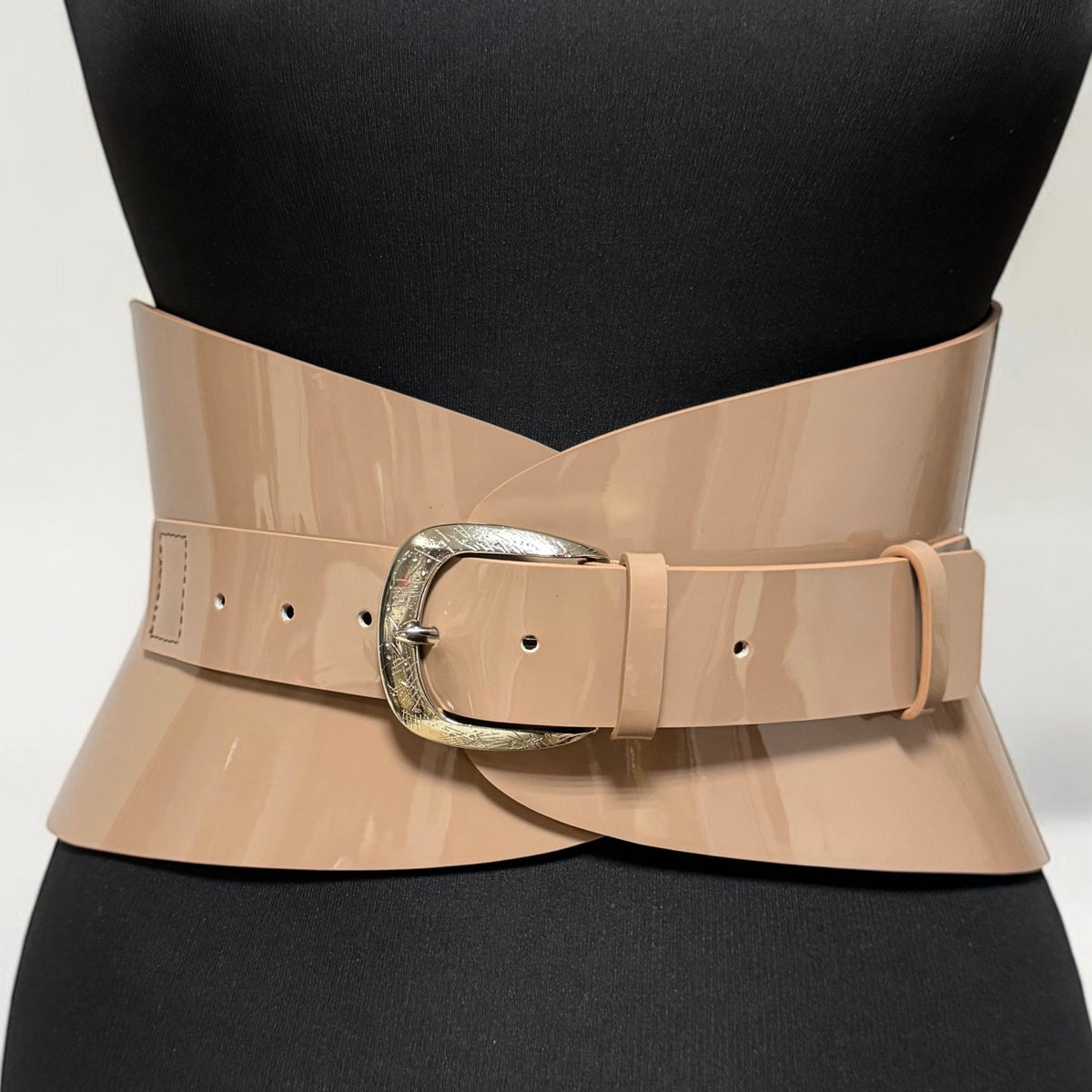 Aria Margo mocha patent leather hourglass corset belt with a metallic buckle on a black mannequin torso.
