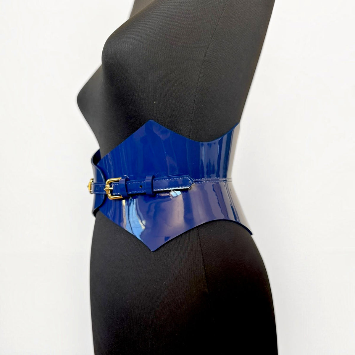 Aria Margo navy blue patent leather corset belt with a high-shine finish and pointed waist-defining silhouette.