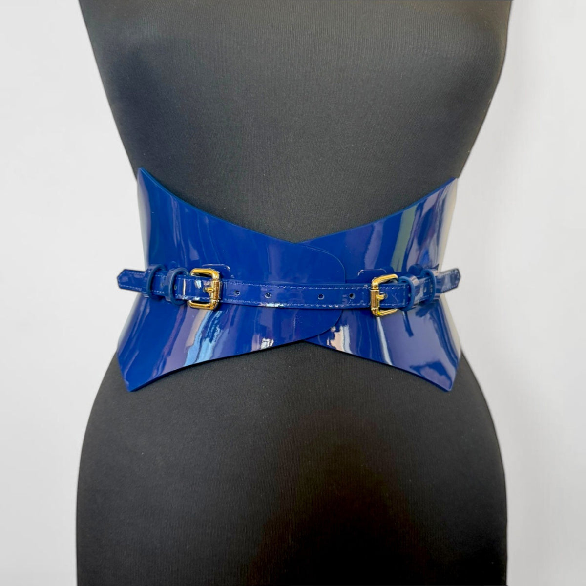 Aria Margo navy blue patent leather corset belt with gold buckles on a mannequin torso