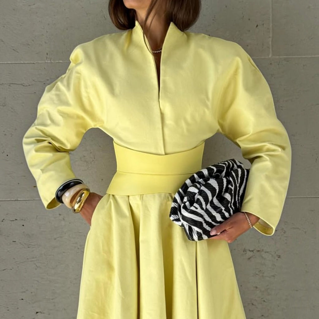 Aria Margo pale yellow leather corset belt worn over a matching yellow dress with a zebra print clutch bag