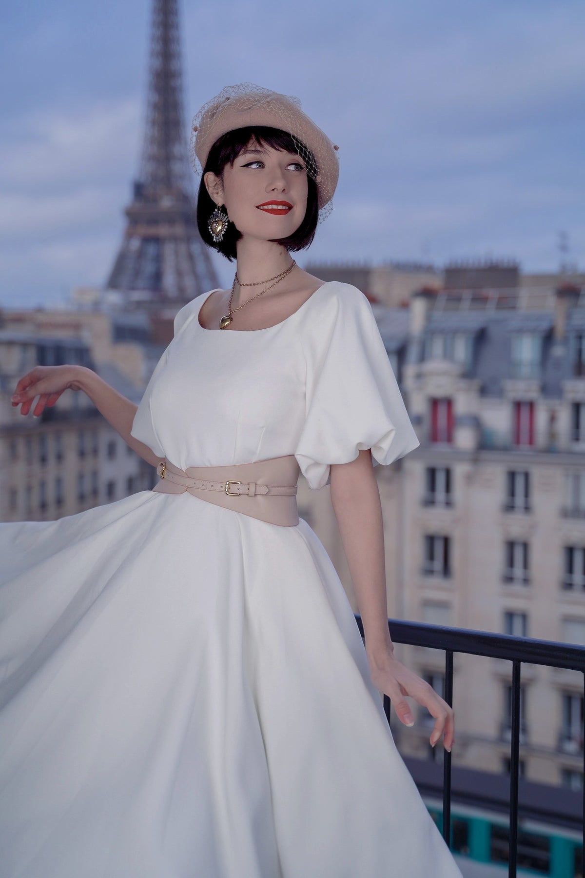 Aria Margo slim beige Italian leather corset belt worn over a white dress with the Eiffel Tower in the background