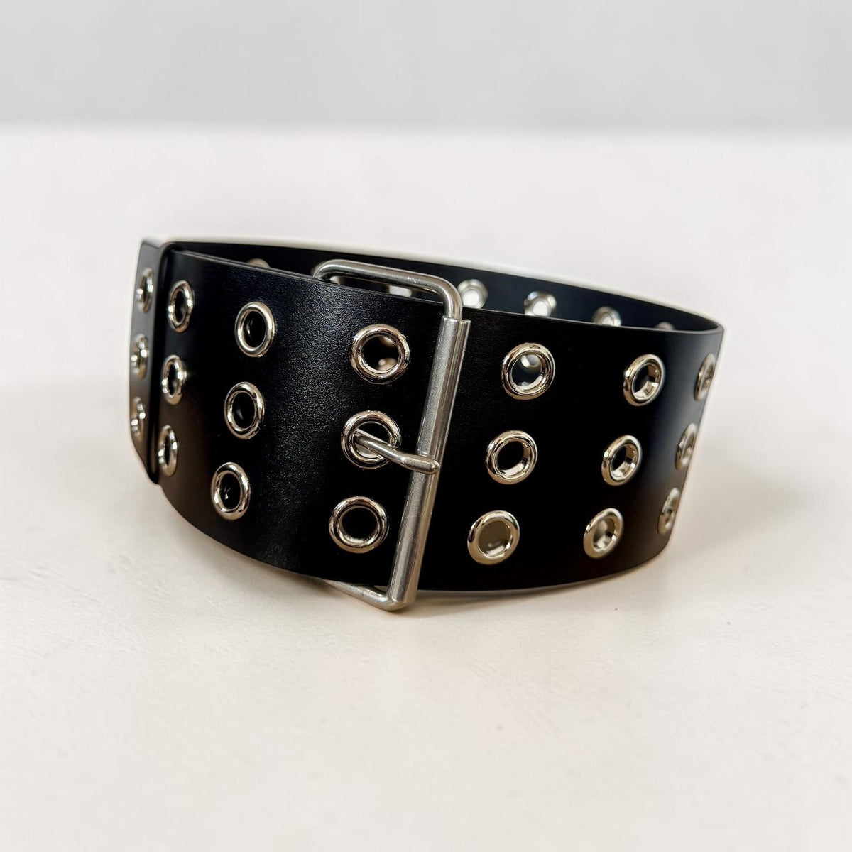 Aria Margo Test black Italian leather coat belt featuring silver-tone eyelets and a double-prong buckle.