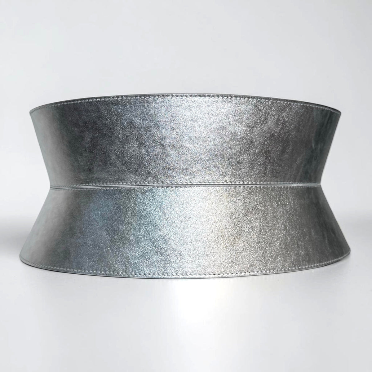 Aria Margo wide silver metallic leather corset belt with an hourglass silhouette and stitched edge details.